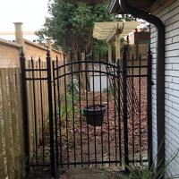 Iron Gate Between Wood Fence & House