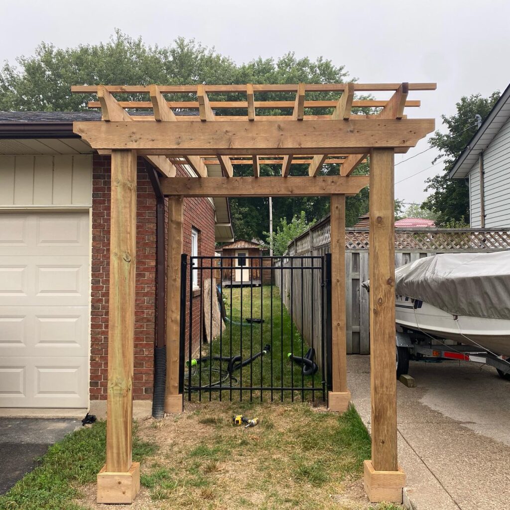 pergola above a single side iron gate fence attached to house
