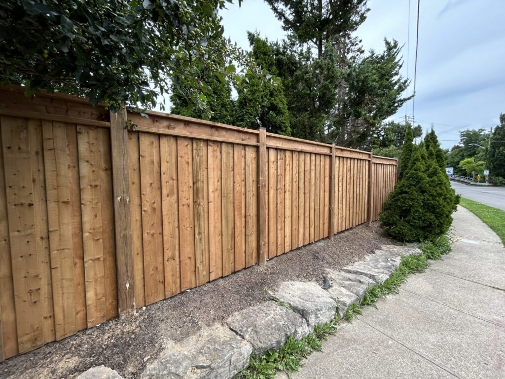 board on board wood privacy fence with top rails and post caps