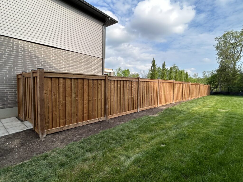 vertical wood privacy fence layered angle and a gate attached to the side of a house