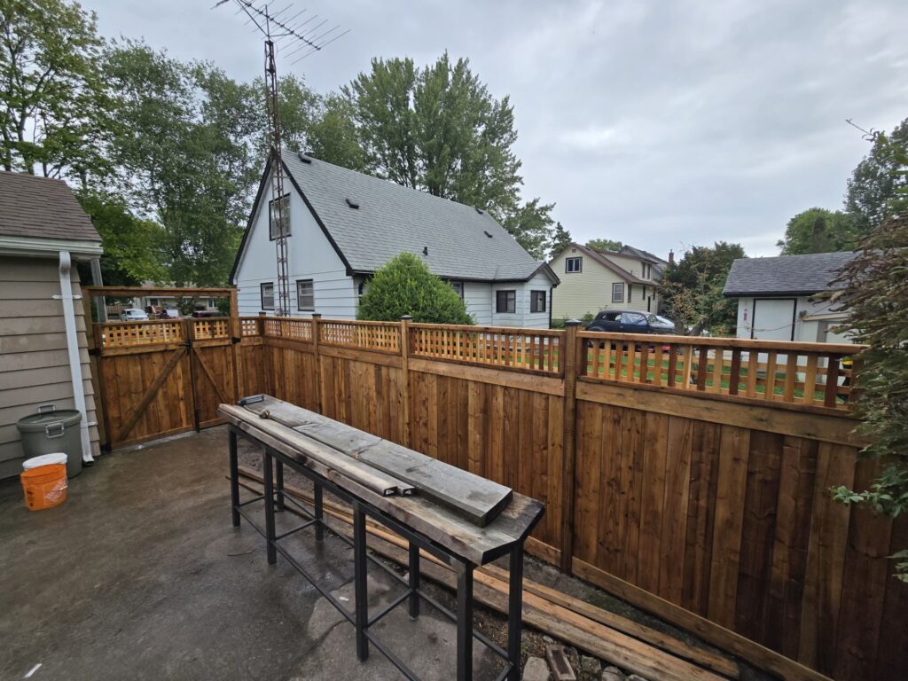 wood privacy fence with lattice top and post caps with a double gate in the backyard