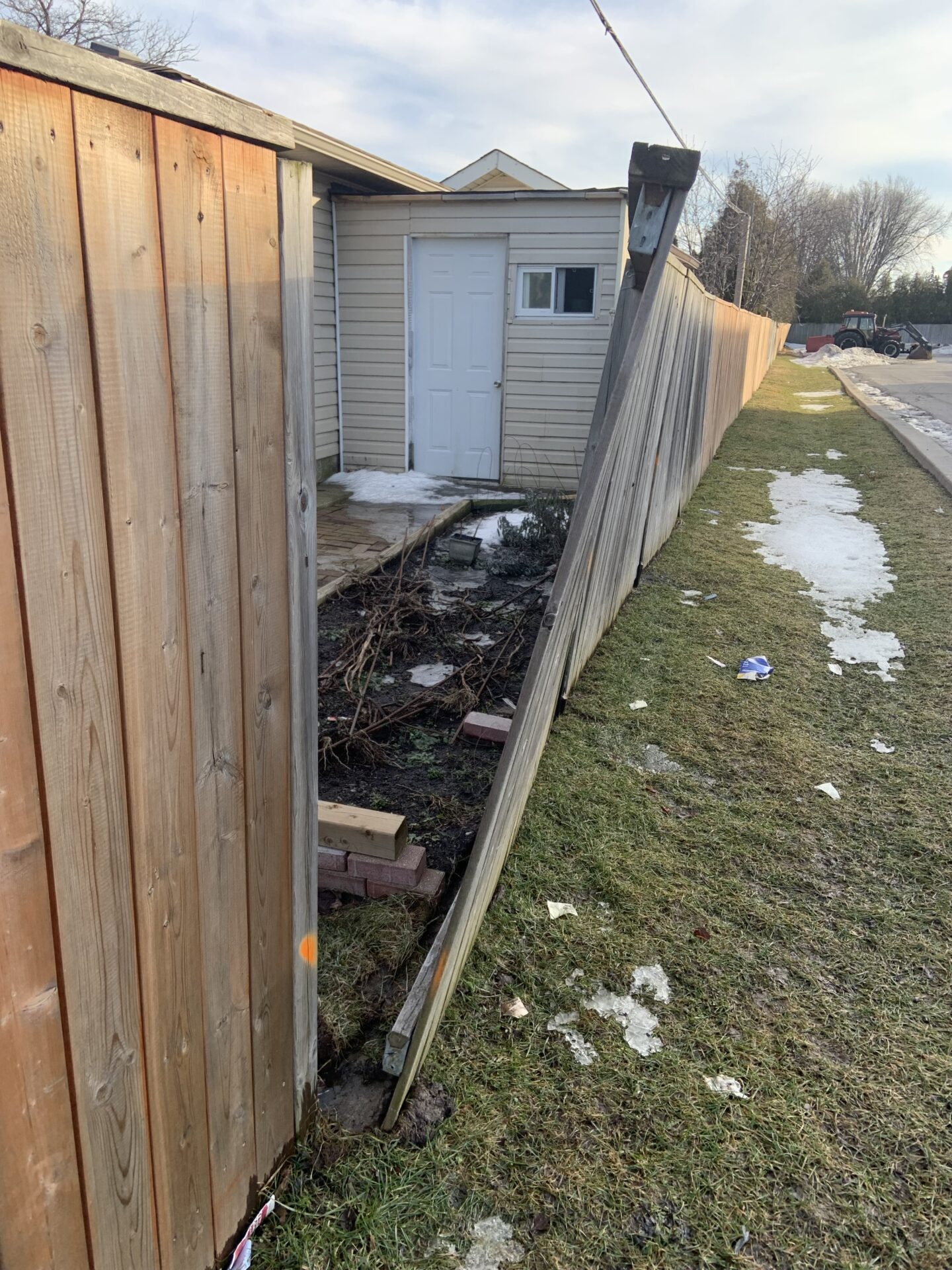 Wood fence with broken fence post that is leaning