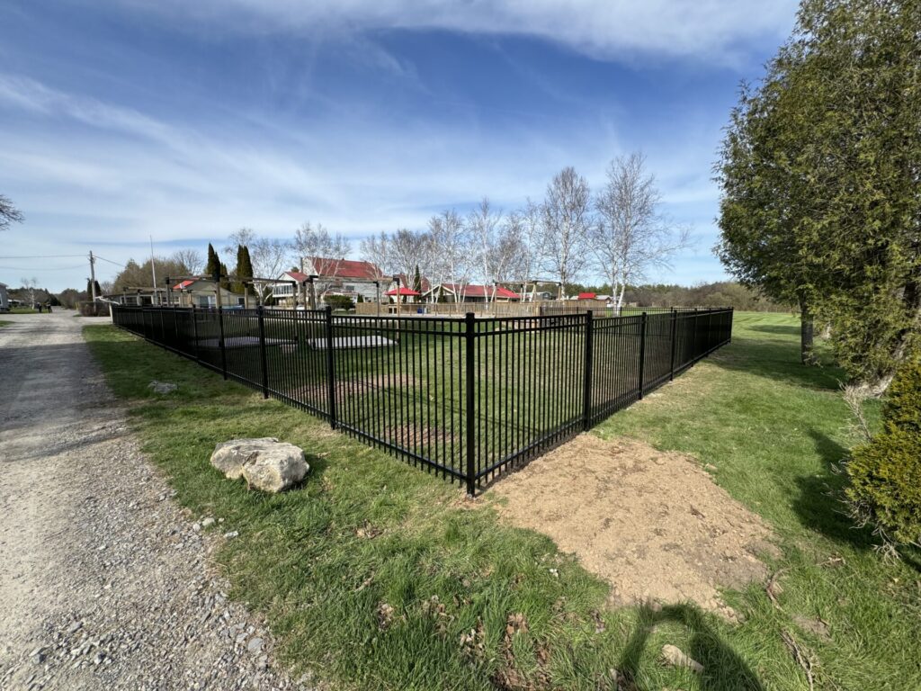 Full wide corner view of a wrought iron fence on large property