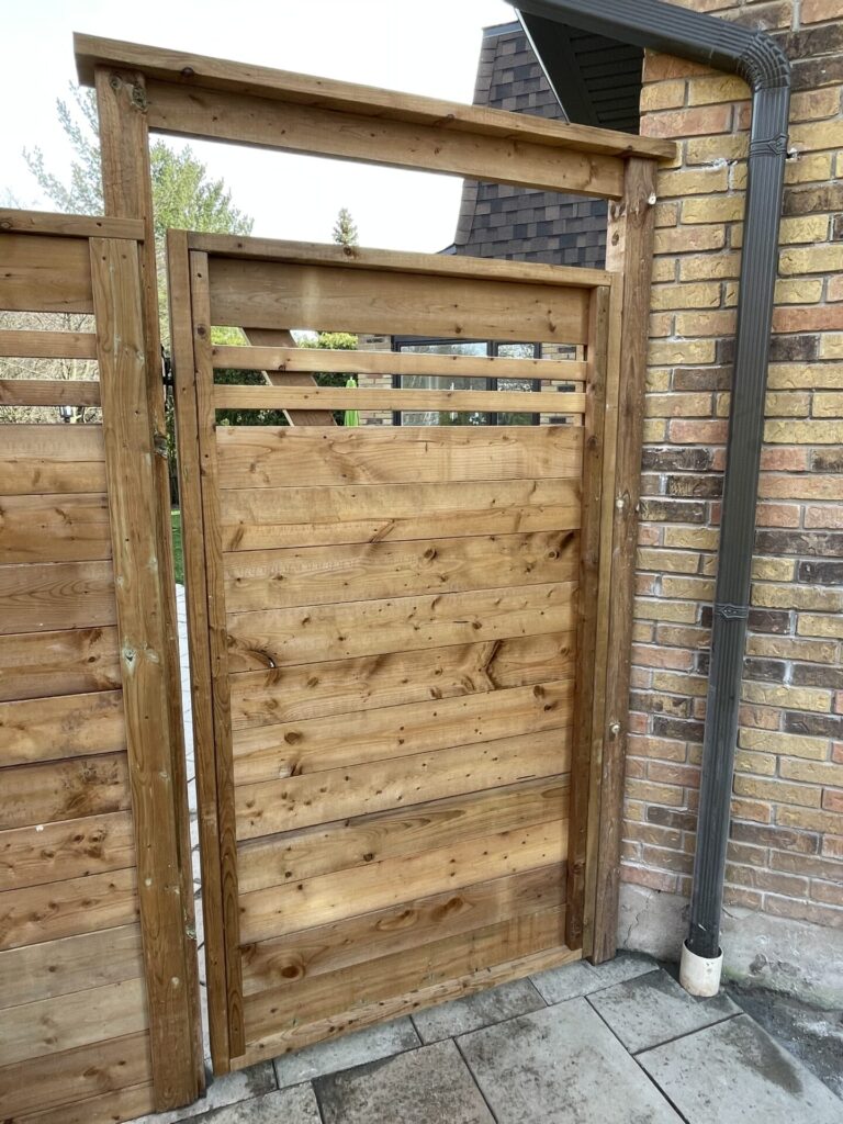 Slatted wood privacy gate with arbour