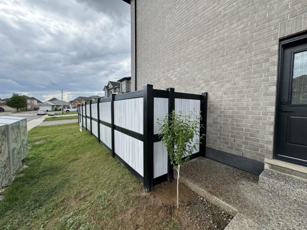 Supernova vinyl fence and gate attached to the side of a house. Black posts and 3 rail system.