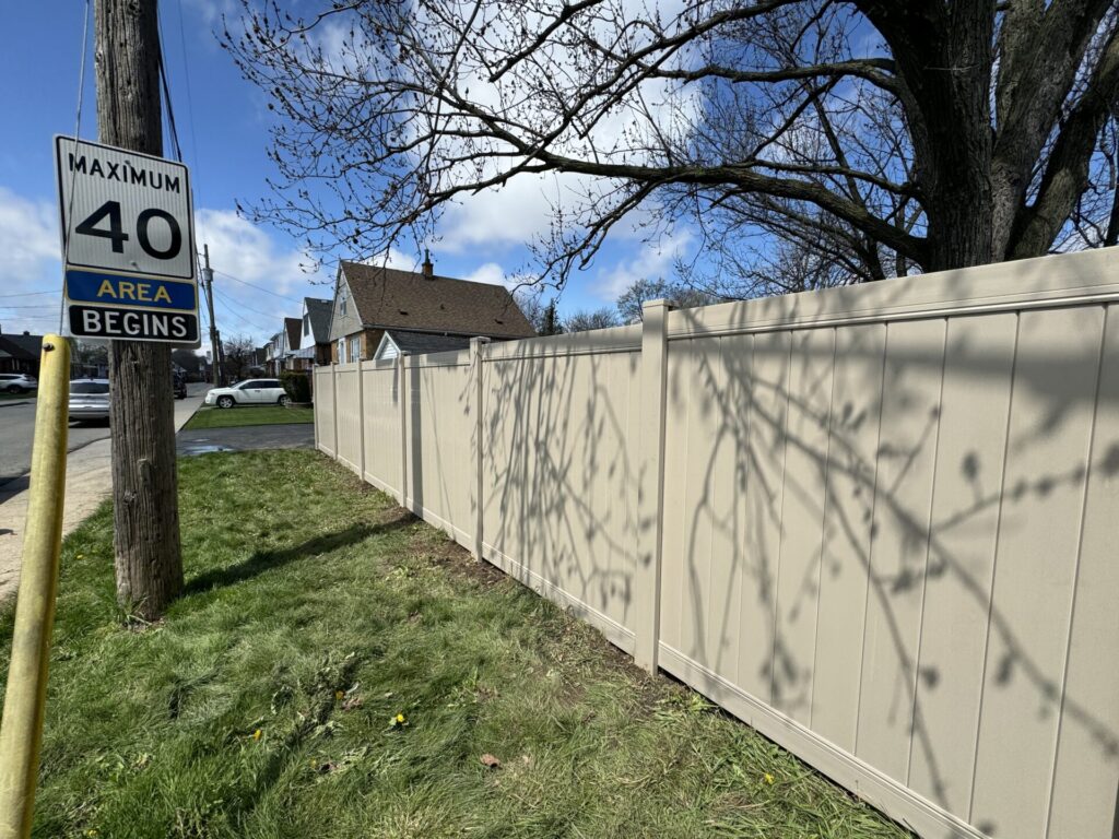 Tan vinyl fence from the street side yard view