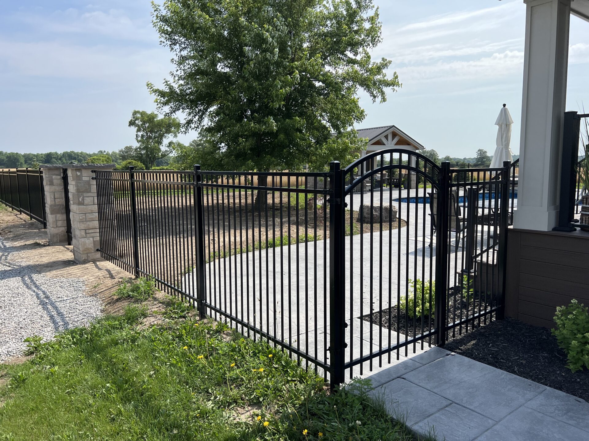 a black iron fence with a pool in the background