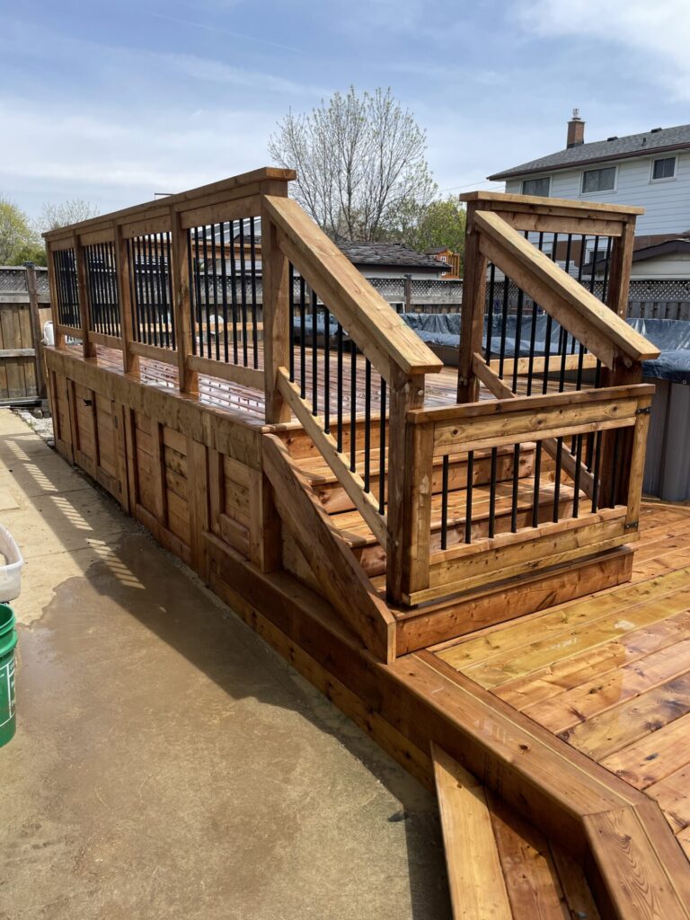 Pool wood deck with stairs and railings with black balusters